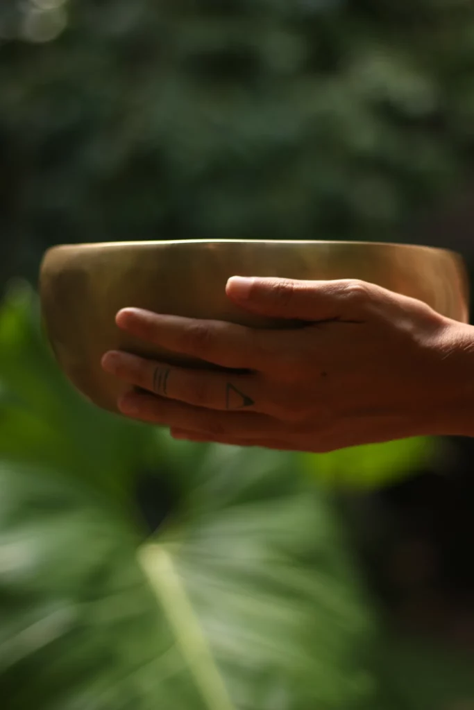 Bol chantant tenu dans les mains, au-dessus d'une grande feuille